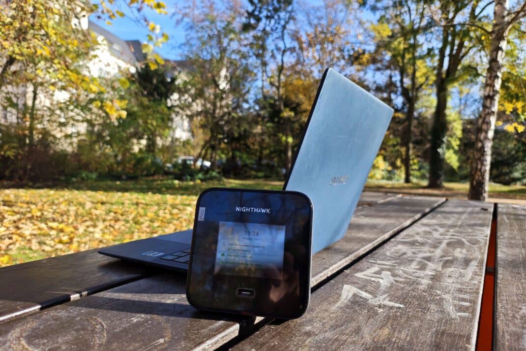 Netgear Nighthawk M7 Pro mit Laptop auf einem Tisch im Park
