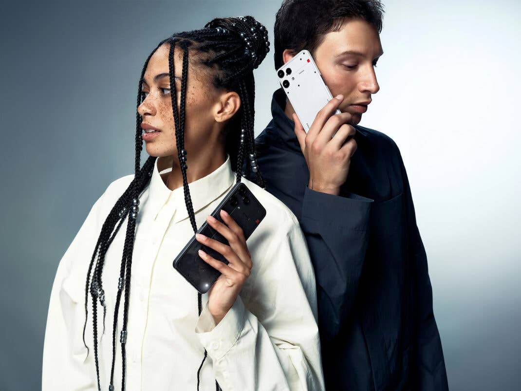 Zwei Personen halten ein Nothing Phone (3a) Lite in der Hand.