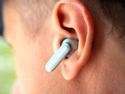 Nahaufnahme eines OnePlus Buds 4 kabellosen Ohrhörers im Ohr.