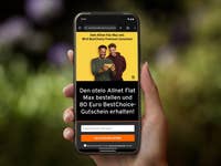 Eine Hand hält ein Smartphone, das eine Anzeige für den otelo Allnet Flat Max mit einem Gutschein über 80 € BestChoice zeigt.