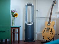 Ein Philips Air Performer AMF870 steht neben einer Gitarre und einer Vase mit Blumen in einem hellen Raum.