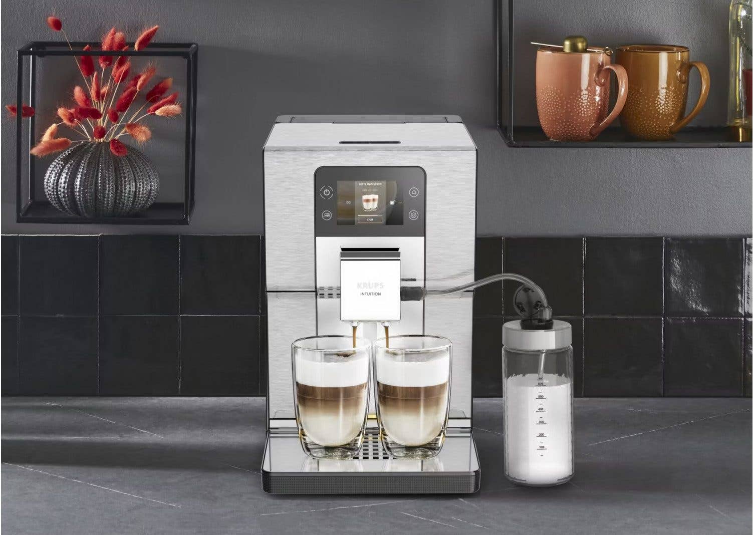 Krups EA877D Intuition Experience+ Kaffeemaschine mit zwei Tassen Kaffee und einem Milchbehälter.