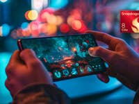 Eine Person hält ein Smartphone mit einer lebhaften Gaming-Szene und einem Snapdragon 8 Elite-Logo.