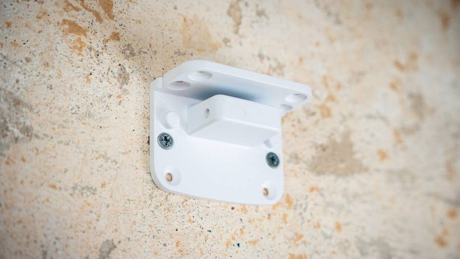 Weiße Halterung an einer strukturierten Wand befestigt.