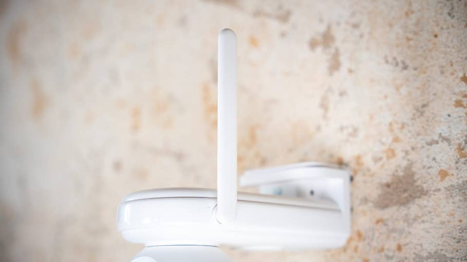 Nahaufnahme einer Reolink Altas PT Ultra-Kamera, die mit einer Antenne an einer Wand montiert ist.