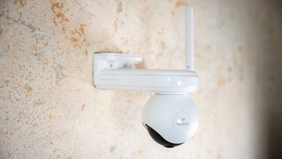 Weiße Reolink Altas PT Ultra Kamera an einer strukturierten Wand montiert.