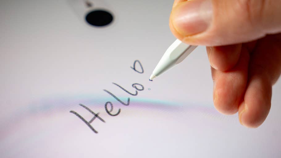 Eine Hand, die einen Stylus hält und 'Hallo.' auf dem Bildschirm eines Samsung Galaxy Tab S11 Ultra 5G schreibt.