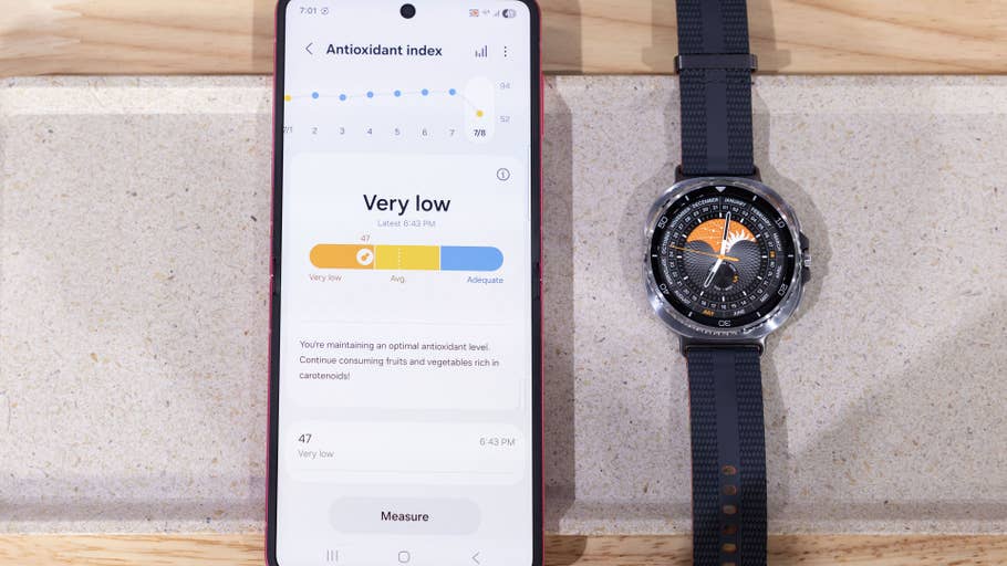Eine Samsung Galaxy Watch 8 Classic neben einem Telefon, das Informationen zum Antioxidantien-Index anzeigt.