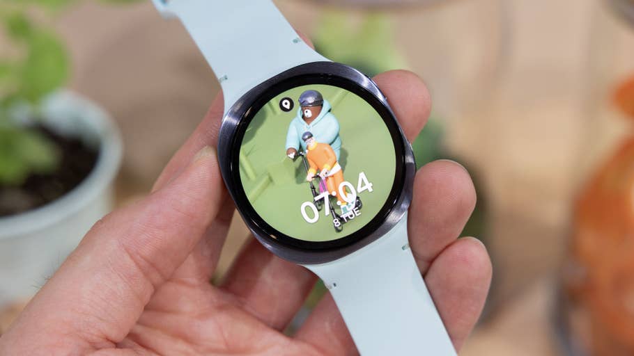 Eine Person hält eine Samsung Galaxy Watch 8, die eine bunte Cartoon-Charakter-Oberfläche zeigt.