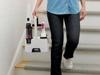 Der Shark StainForce wird eine Treppe heruntergetragen in seiner Tragevorrichtung.