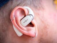 Nahaufnahme von Shokz OpenFit 2 kabellosen Ohrhörern, die in einem Ohr sitzen.