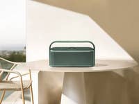 Ein grüner Anker Soundcore Motion X600 Bluetooth-Lautsprecher auf einem Tisch in einer Außenumgebung.
