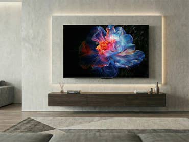 Ein Smart-TV, der farbenfrohe Blumenkunst in einem modernen Wohnzimmer zeigt.