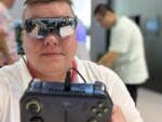 Person mit VR-Brille hält ein Spielgerät auf einer Tech-Veranstaltung.