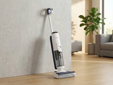 Ein Tineco Nass- und Trockensauger lehnt an einer Wand in einem modernen Wohnzimmer.