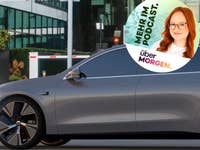 Ein elegantes graues NIO-Elektrofahrzeug, das in einer städtischen Umgebung geparkt ist, mit einem Podcast-Werbegrafik daneben.