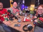 Johanna, Fabi und Casi sitzen zusammen in einem Podcast-Studio und tragen Weihnachtspullover