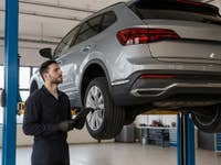 Auto auf einer Hebebühne in einer Werkstatt.