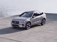 Volvo XC60 Recharge steht an einem See.