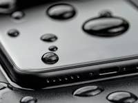 Ein Smartphone mit Wassertropfen auf der Oberfläche, das Wasserdichtigkeit zeigt.