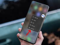 Eine Hand hält ein Smartphone, das ein Menü mit Optionen anzeigt, einschließlich der hervorgehobenen Option 'Deinstallieren'.