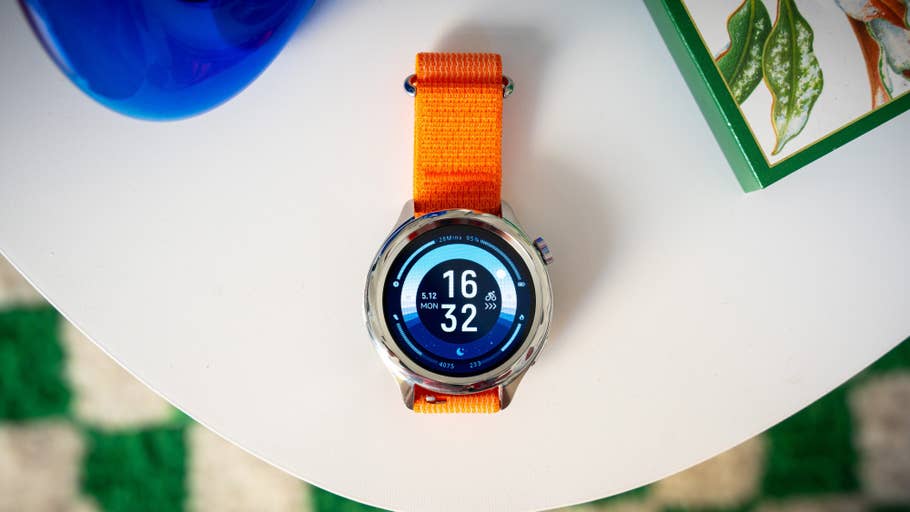 Eine Xiaomi Watch S4 auf einem Tisch, die Uhrzeit und Datum anzeigt.