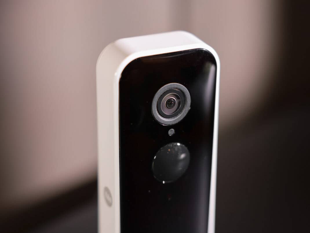 Eine Detailansicht des oberen Teils der Yale Video-Türklingel, die das kreisförmige Kamera-Objektiv und den darunter liegenden Sensor auf der schwarzen Frontseite zeigt.